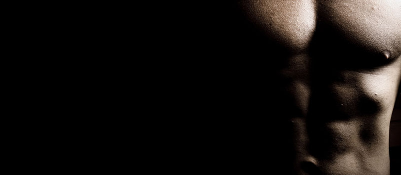 Scultped male body against black background